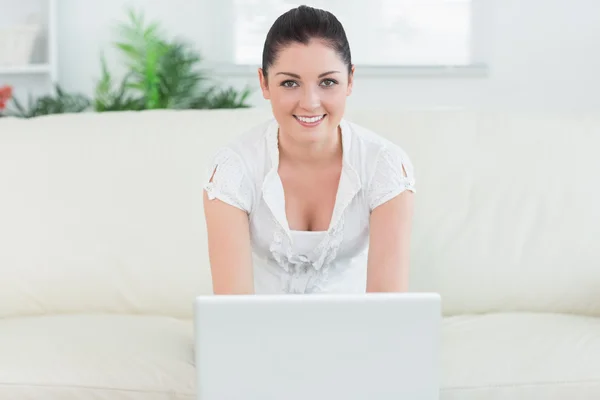 Vrouw zitten op de Bank en het gebruiken van laptop — Stockfoto