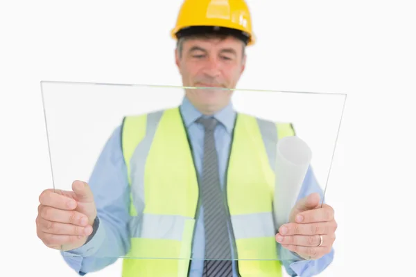 Man holding a huge glass slide while viewing it — Zdjęcie stockowe