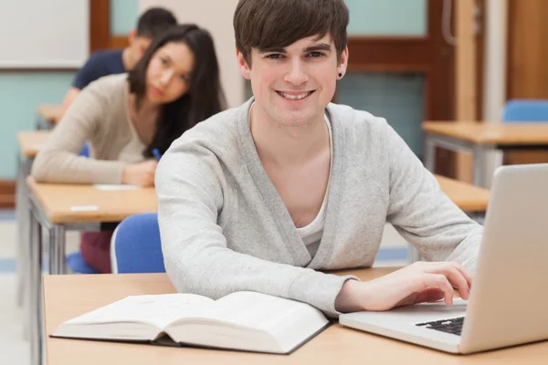 Schüler sitzt mit Laptop im Klassenzimmer — Stockfoto
