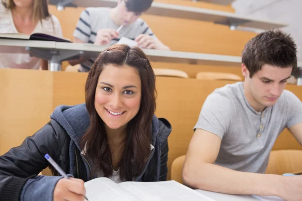 Student writing at the lecture hall — Stock Photo, Image