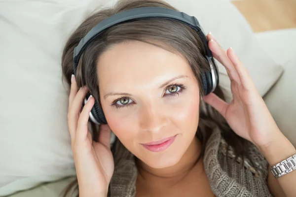 Mulher calma usando fones de ouvido para ouvir música — Fotografia de Stock