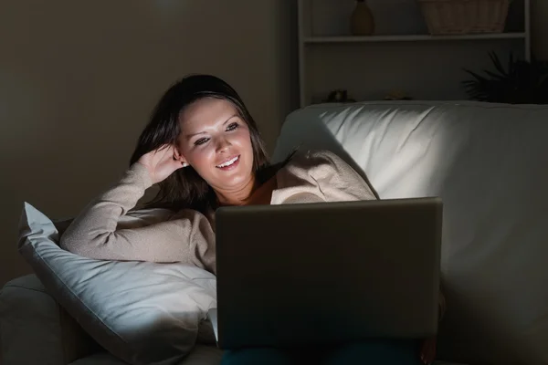 Vrouw liggend op de Bank met haar laptop in nacht — Stockfoto