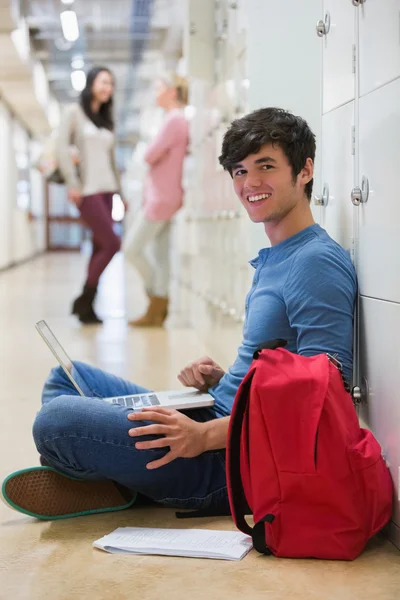 Uomo seduto sul pavimento al corridoio sorridente — Foto Stock