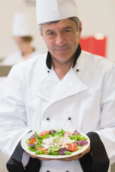 Cheerful chef apresentando sua salada — Fotografia de Stock