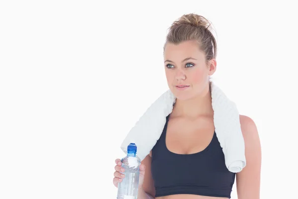 Woman standing holding a bottle of water and a towel — Stock Photo, Image