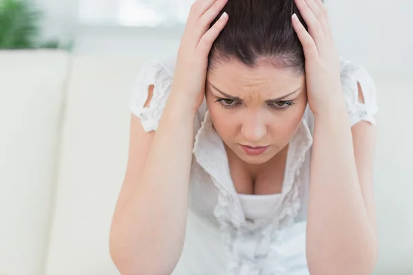 Annoyed woman sitting on the couch — Stock Photo, Image