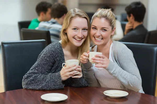 Mujeres sentadas en la cafetería sosteniendo tazas —  Fotos de Stock