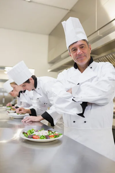 Gelukkig chef-kok met anderen voorbereiden salades — Stockfoto