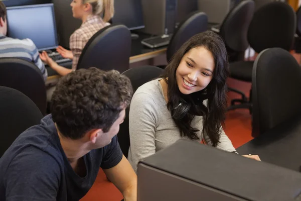 Paar sitzt lächelnd am Computer — Stockfoto