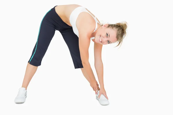 Woman standing while stretching and smiling — Stock Photo, Image