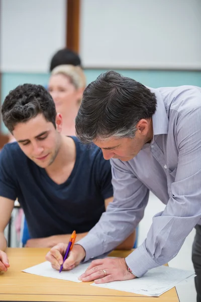 Lärare att göra anteckning om studenter arbete — Stockfoto