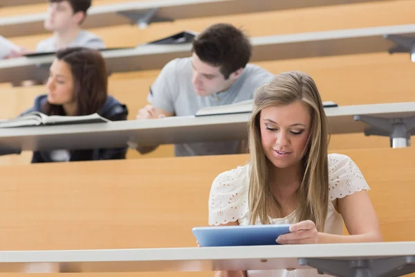 Student sedí v přednáškovém sále držení počítače tablet pc — Stock fotografie