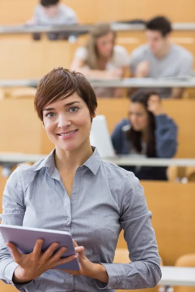 Woman standing holding a tablet computer smiling — Stock Photo, Image