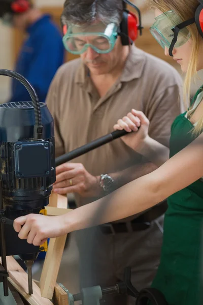 Woman standing at a drill machine — Stock Photo, Image