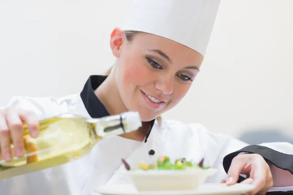 Chef derramando óleo sobre salada — Fotografia de Stock