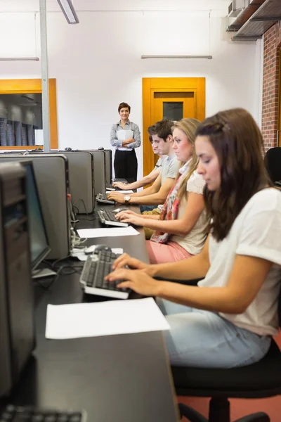 Estudiantes sentados en la computadora concentrándose — Foto de Stock