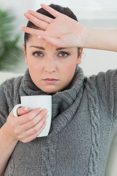 Kvinna sitter i soffan och mår dåligt — Stockfoto