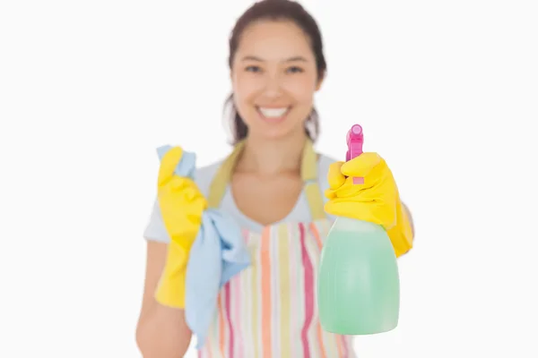 Smiling woman holding up spray bottle — Stock Photo, Image