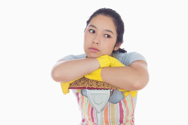 Gelangweilte Frau lehnt sich an einen Wischmopp — Stockfoto