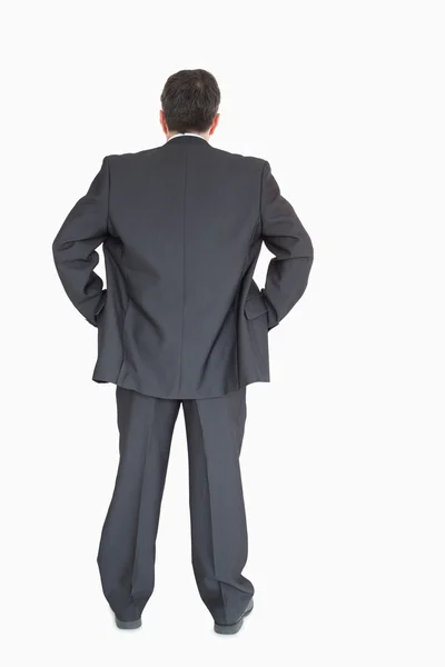 Businessman standing back to the camera with hands on hip — Stock Photo, Image