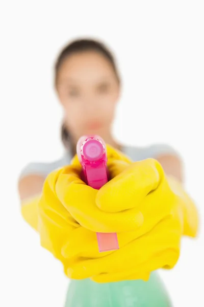 Confident woman pointing a spray bottle at the camera — Stock Photo, Image