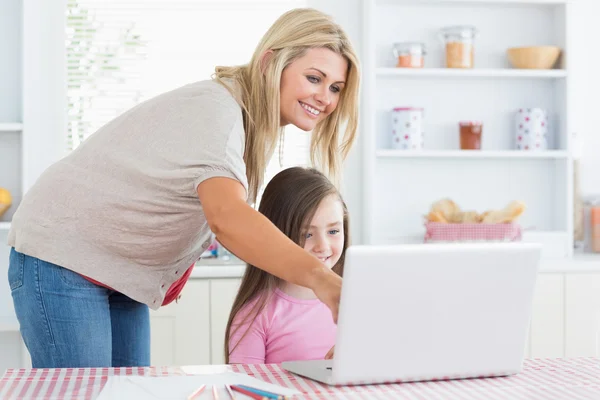 Mãe apontando para laptop com filha — Fotografia de Stock