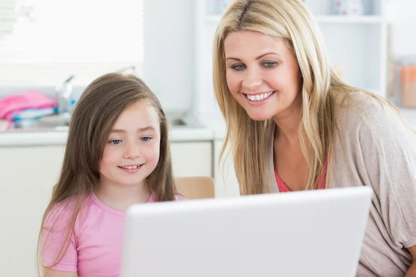 Woman and girl looking at the laptop monitor — Stock Photo, Image