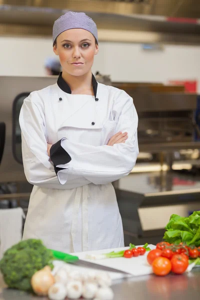 Шеф-повар стоит рядом с доской и овощами — стоковое фото