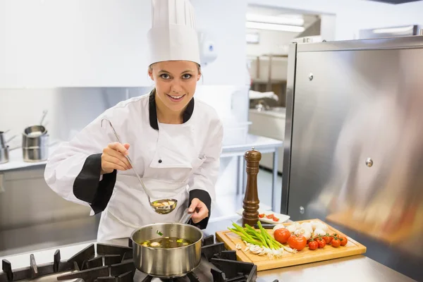 Kvinna provsmakning soppa medan matlagning — Stockfoto