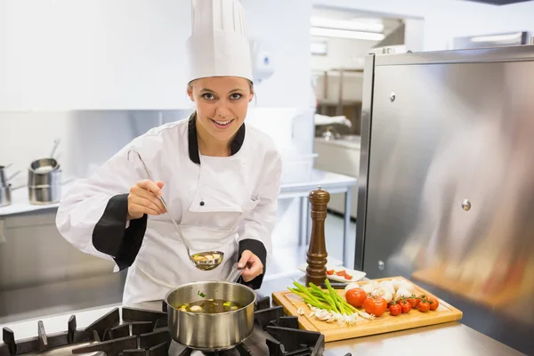 Woman tasting soup while cooking — Stock Photo, Image