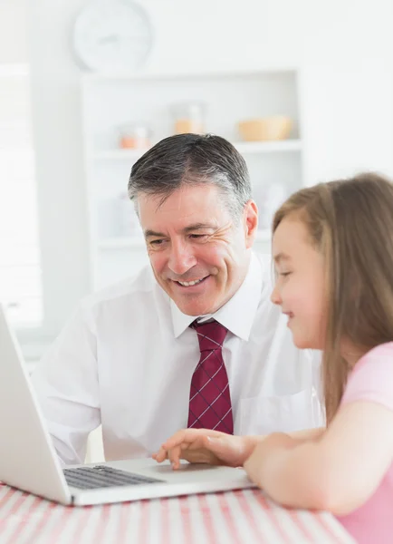 Daughter and father using laptop together — Stock Photo, Image