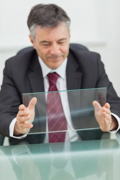 Homem de negócios sorrindo segurando uma tela virtual — Fotografia de Stock