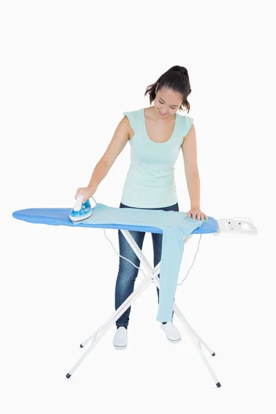 Smiling woman ironing blue jumper — Stock Photo, Image