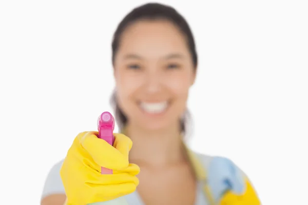 Smiling woman spraying ahead — Stock Photo, Image