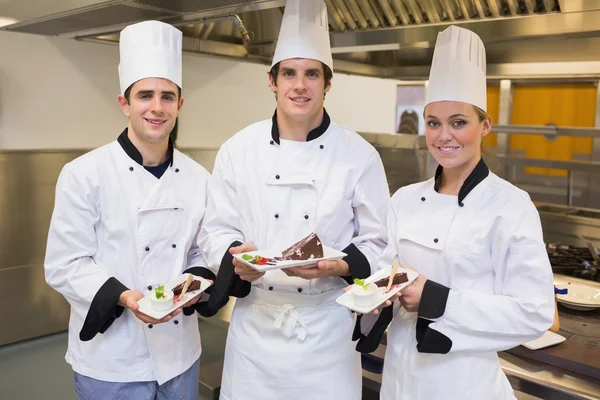 Three Chef's presenting cakes — Stock Photo, Image