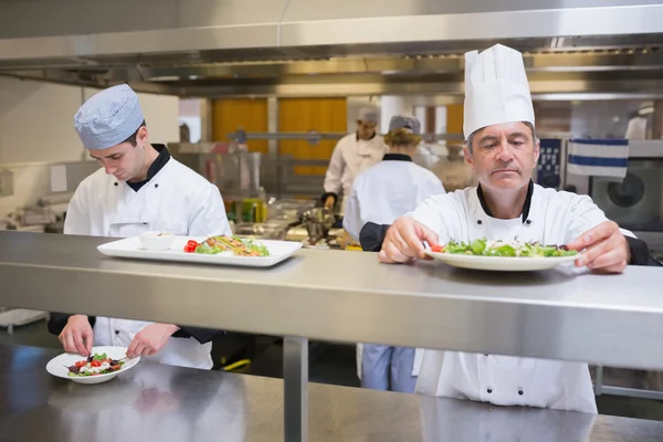 Chef cuisinier inspectant la salade avant le service — Photo