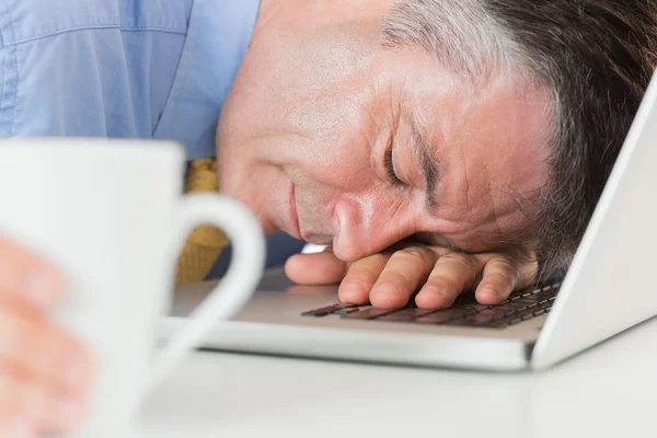 Geschäftsmann schläft auf seinem Laptop beim Kaffee — Stockfoto
