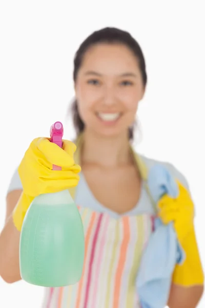 Lachende vrouw holding spray fles en doek — Stockfoto