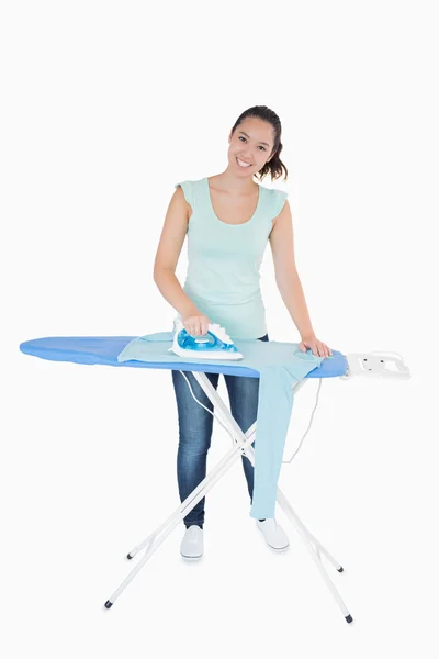 Smiling woman ironing jumper — Stock Photo, Image