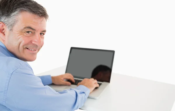 Uomo sorridente che lavora con il computer portatile — Foto Stock