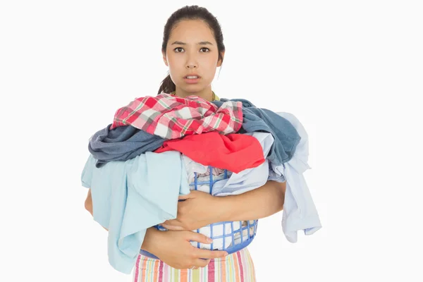 Mulher franzina segurando cesta que está cheia de roupa suja — Fotografia de Stock