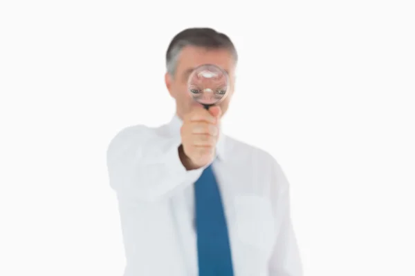 Businessman behind magnifying glass — Stock Photo, Image