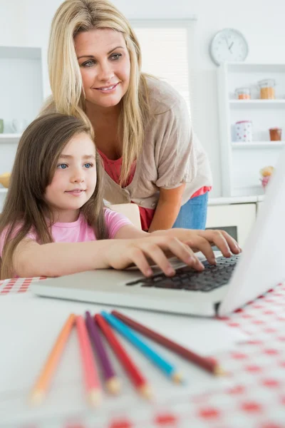 Mulher de pé olhando para Filha digitação — Fotografia de Stock