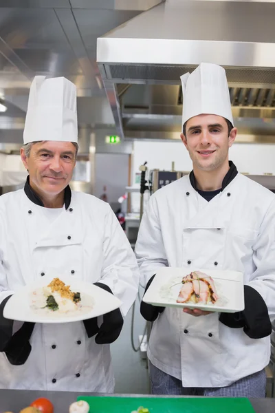 Glimlachen van chef-kok presentatie van hun gerechten — Stockfoto
