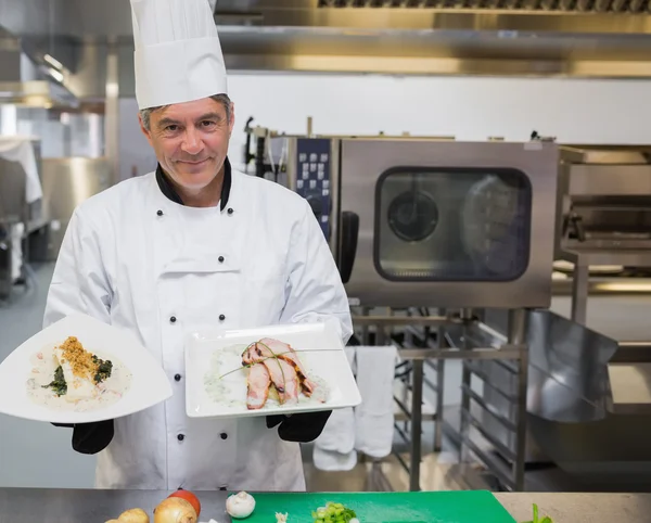 Chef segurando duas placas na cozinha — Fotografia de Stock