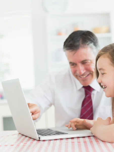 Man sitting with his daughter at the kitchen at laptop — Stock Photo, Image