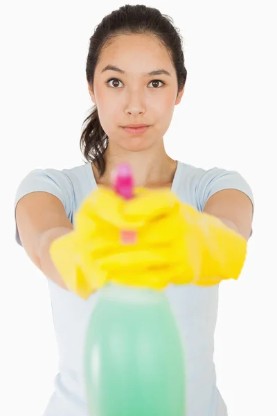 Brunette woman pointing spray bottle — Stock Photo, Image