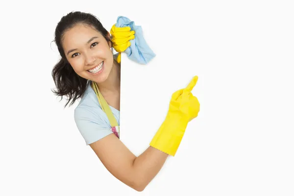 Vrouw in rubber handschoenen wijzend naar het witte oppervlak — Stockfoto