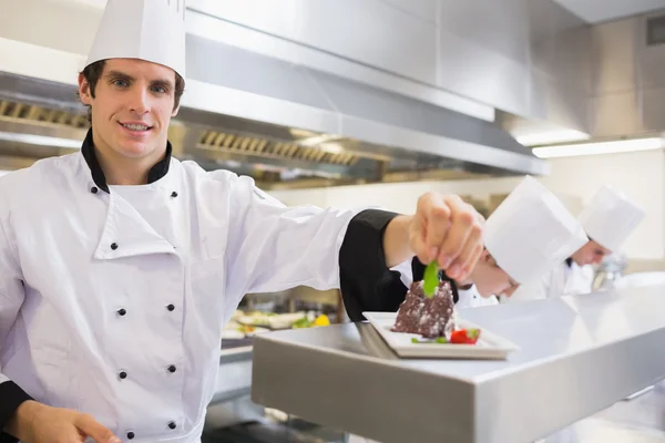 Lachende chef-kok bijgerechten zijn taart — Stockfoto