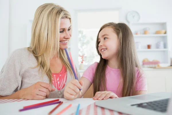 Kvinna och dotter ler mot varandra och rita — Stockfoto